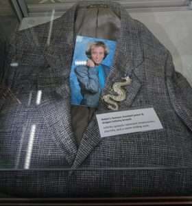 Robin Gibb checked jacket and dragon infinity brooch